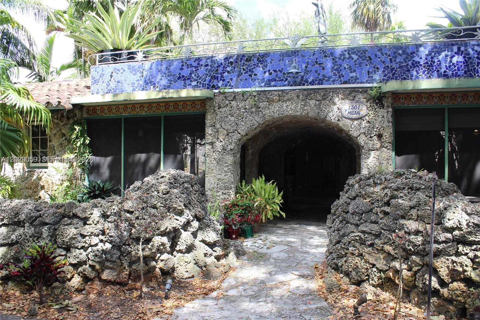 A stone house features a central arched entryway and a blue mosaic tiled balcony railing — 1301 MILAN AVE # 3, Coral Gables FL 33134, CORAL GABLES, FL