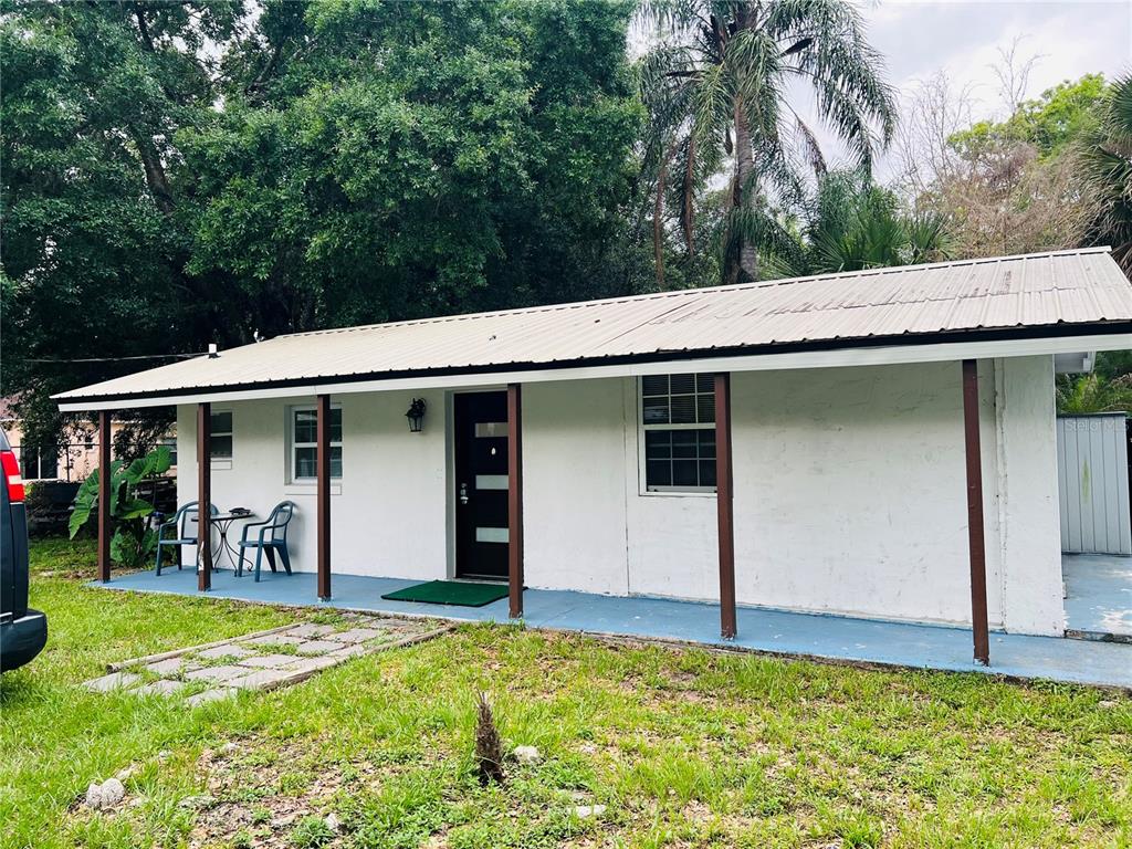 A white, single-story house with a metal roof and a covered front porch — 1218 KINGSTON AVENUE, ORLANDO, FL