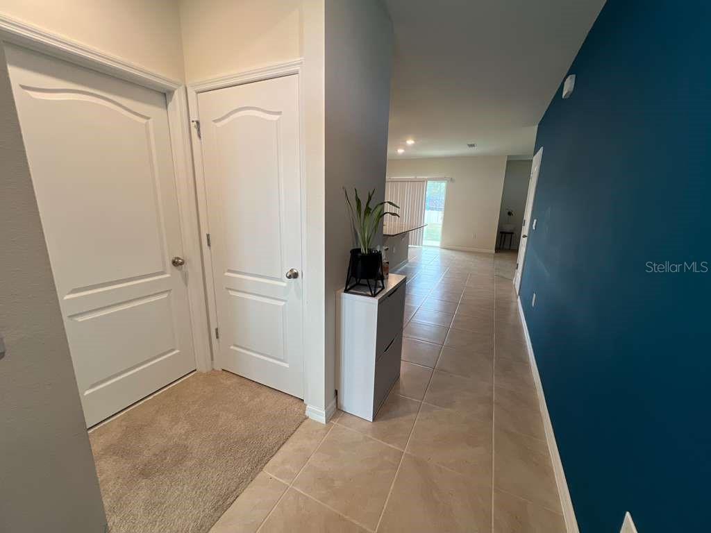 A tiled entryway leads into a living area with a dark blue accent wall — 2131 DOE RUN DRIVE, DAVENPORT, FL
