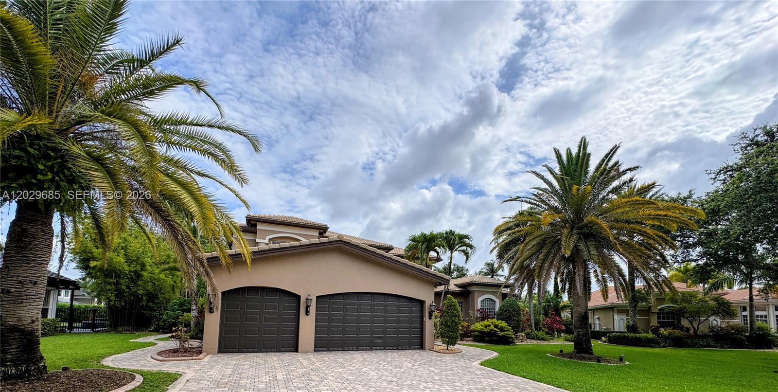 A two-story house with a two-car garage and palm trees in the front yard — 10445 Canterbury Ct, Davie FL 33328, DAVIE, FL