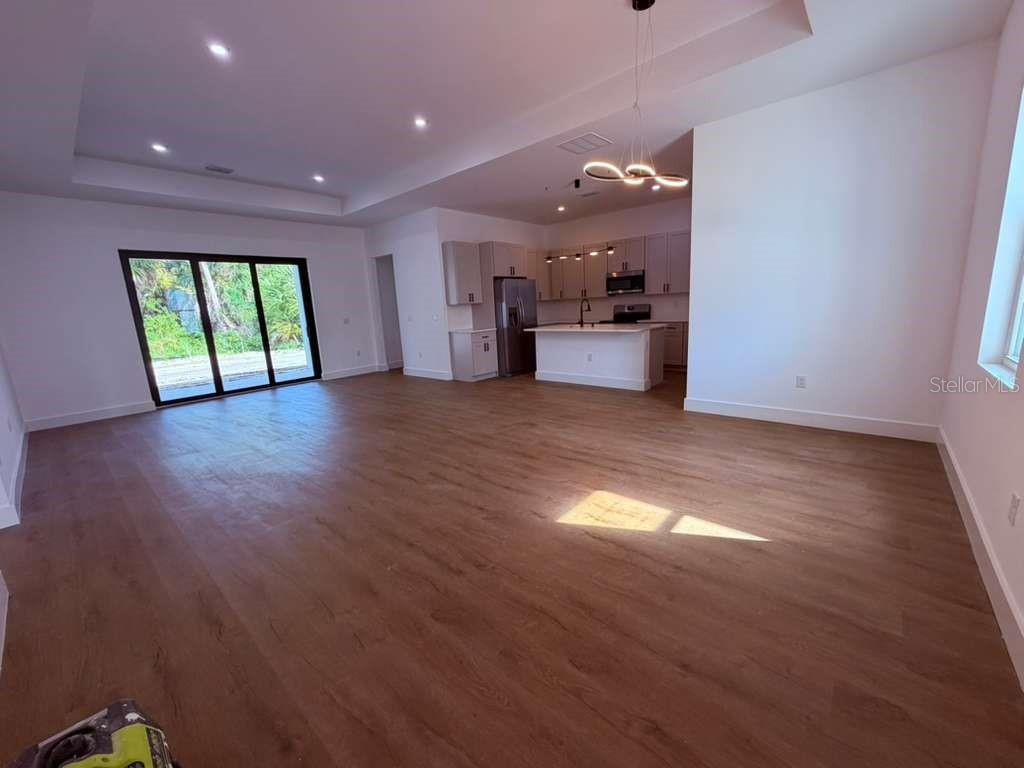 A newly constructed white house with a black garage door and unfinished dirt yard — 3407 CULPEPPER TERRACE, NORTH PORT, FL