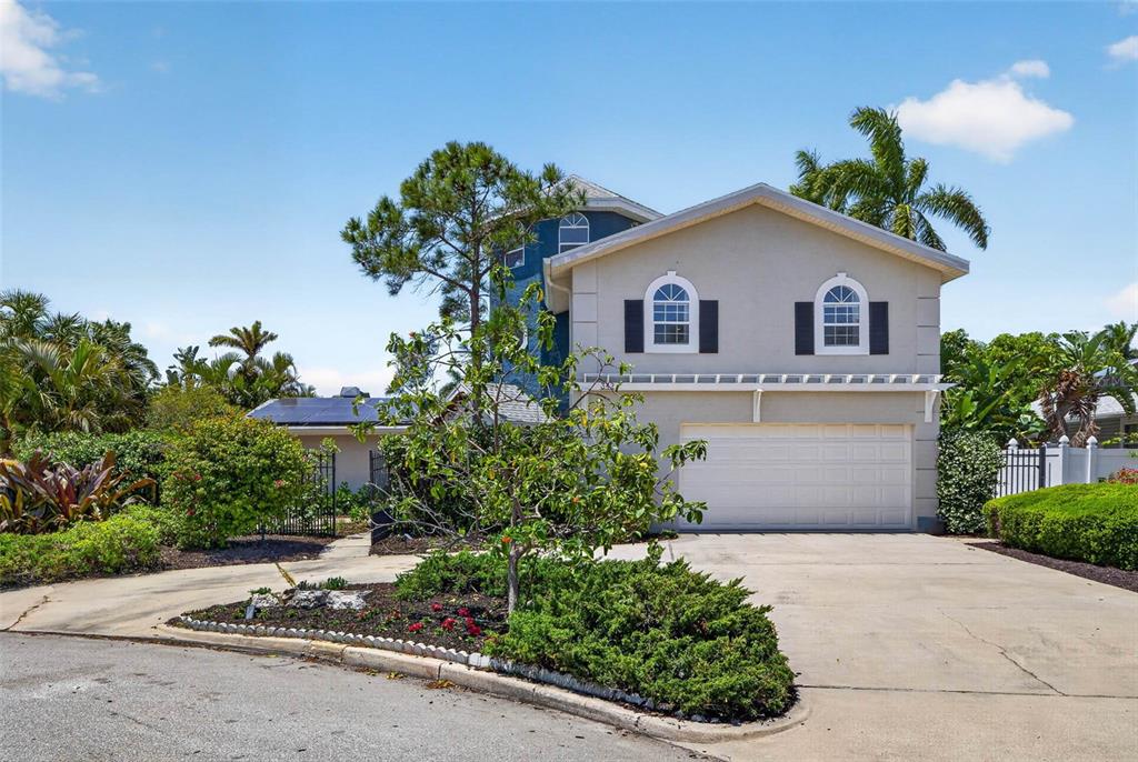 A two-story house with a garage, arched windows, and a blue tower section — 342 2ND AVENUE N, TIERRA VERDE, FL