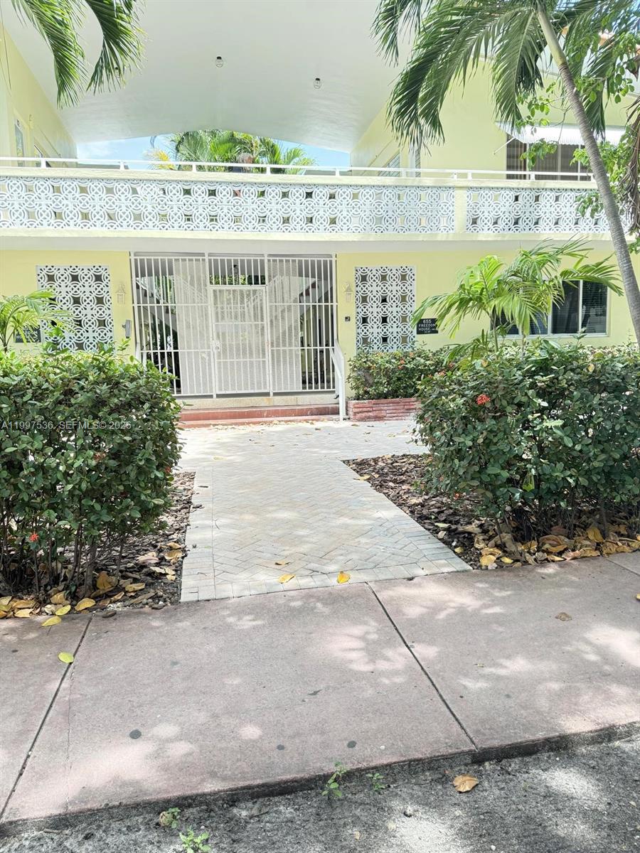 A paved walkway leads to the gated entrance of a two-story yellow apartment building — 655 Meridian Ave # 2, Miami Beach FL 33139, MIAMI BEACH, FL