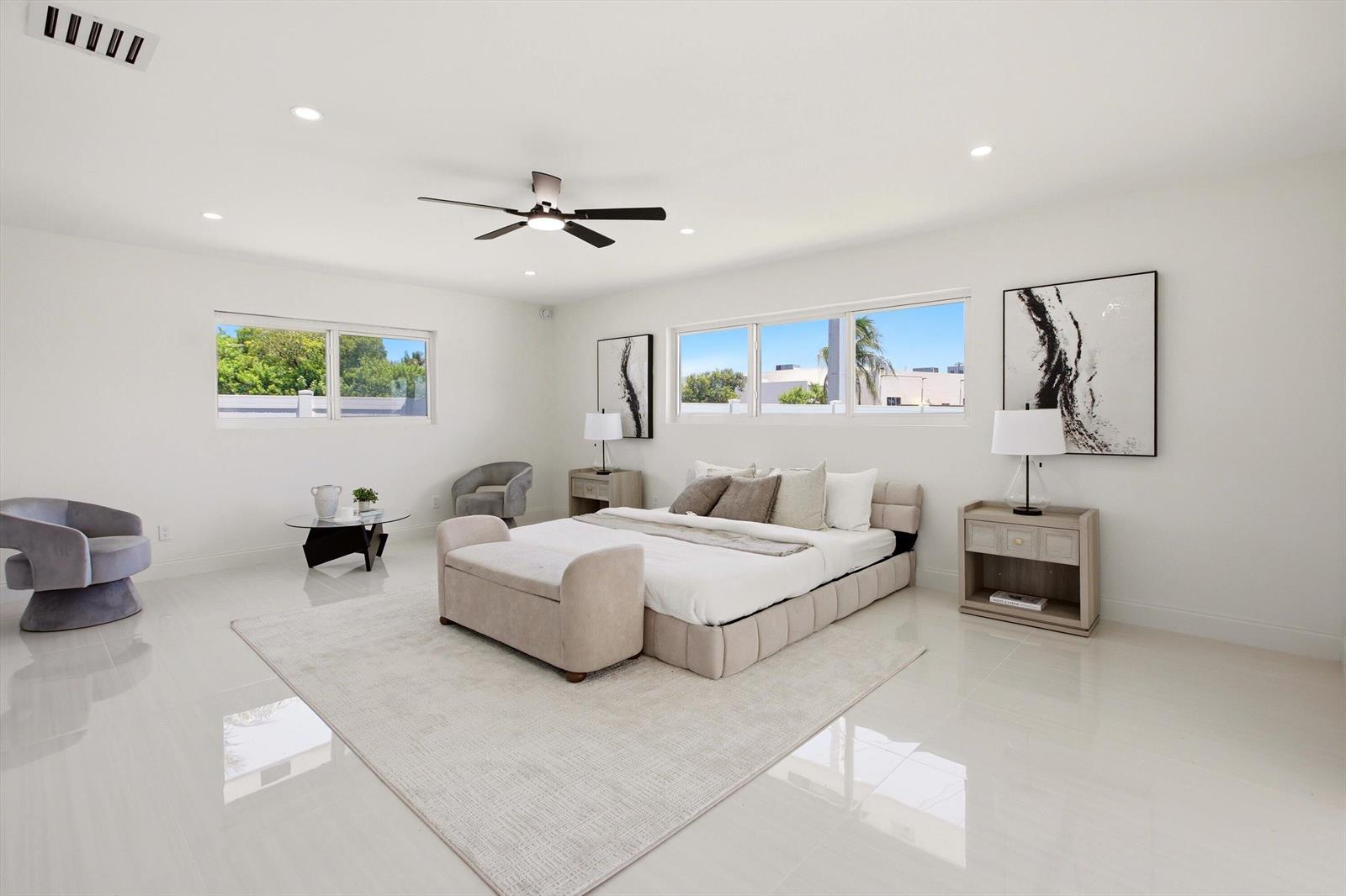 A bright, modern bedroom features white walls, tile flooring, a bed with a bench, and windows — 401 NW 3rd Place, Dania Beach FL 33004, DANIA BEACH, FL