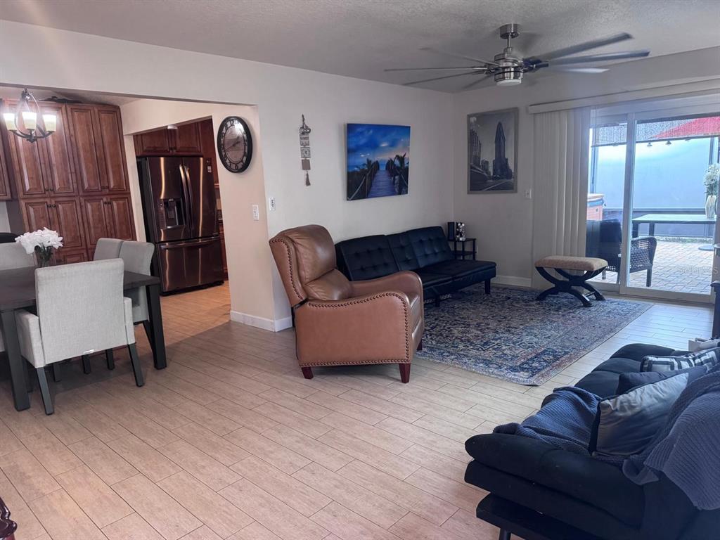 A living room and dining area feature wood-look tile flooring, a ceiling fan, and furniture — 5424 SERENE LANE, ORLANDO, FL