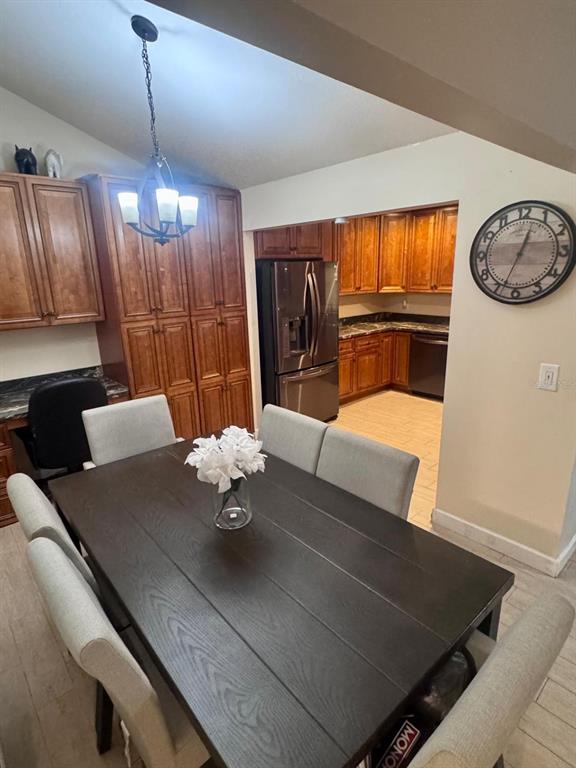 A dining room with a dark wood table and chairs sits adjacent to a kitchen — 5424 SERENE LANE, ORLANDO, FL