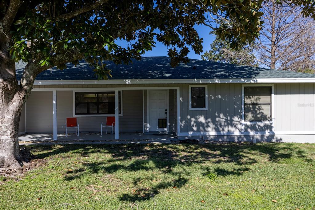 The exterior of a single-story house features light-colored siding, a covered porch, and a lawn — 15181 NE 9TH STREET, WILLISTON, FL