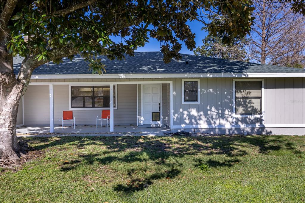 A single-story house with light gray siding, a covered front porch, and a large tree — 15181 NE 9TH STREET, WILLISTON, FL