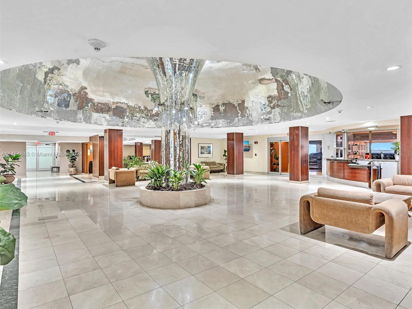 A spacious lobby features a central mirrored column, a reflective ceiling dome, and tile flooring — 2655 Collins Ave # 706, Miami Beach FL 33140, MIAMI BEACH, FL