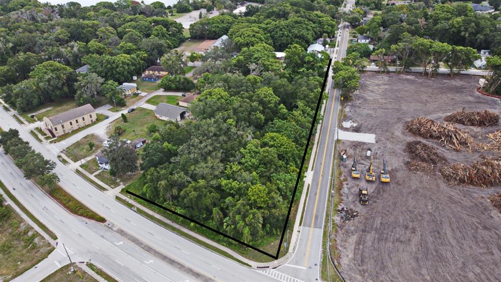 An aerial view shows a wooded, triangular lot bordered by two roads and cleared land — S RONALD REAGAN BOULEVARD, ALTAMONTE SPRINGS, FL
