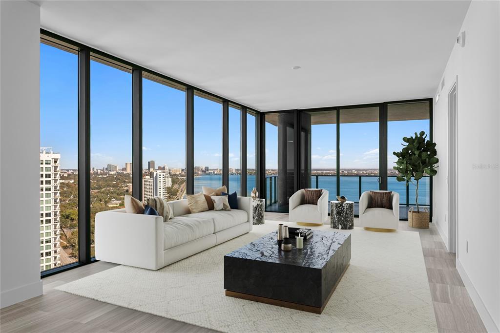 A modern living room features floor-to-ceiling windows with panoramic water and city views — 3015 S YSABELLA AVENUE UNIT 2301, TAMPA, FL