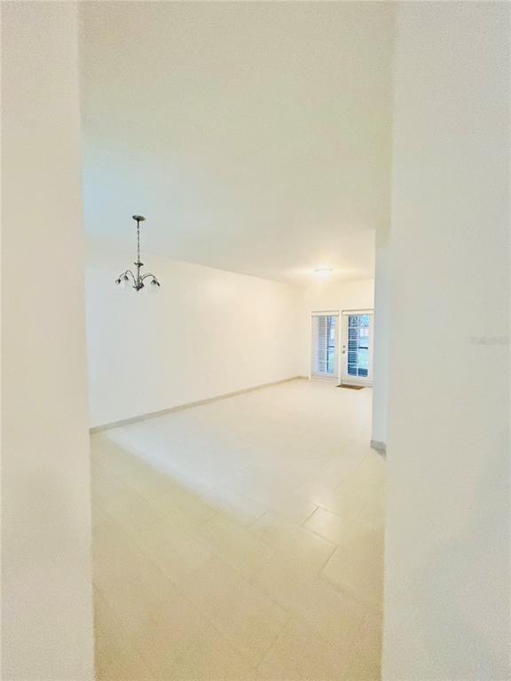 A kitchen features stainless steel appliances, white cabinets, and speckled granite countertops — 3508 WINDY WALK WAY UNIT 6101, ORLANDO, FL