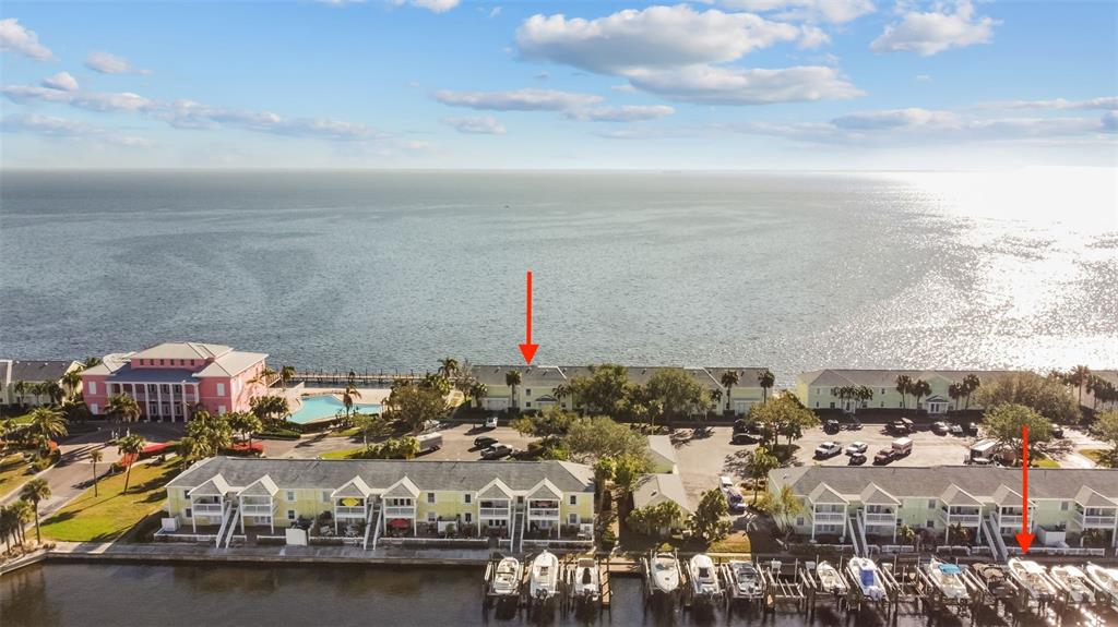 An aerial view shows waterfront townhomes with boat slips and a swimming pool — 5026 COQUINA KEY DRIVE SE UNIT 5026, ST PETERSBURG, FL
