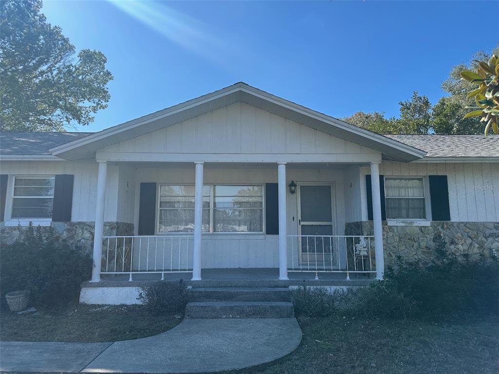 A single-story house with white siding, stone accents, and a covered front porch — 200 S DESOTO STREET, BEVERLY HILLS, FL