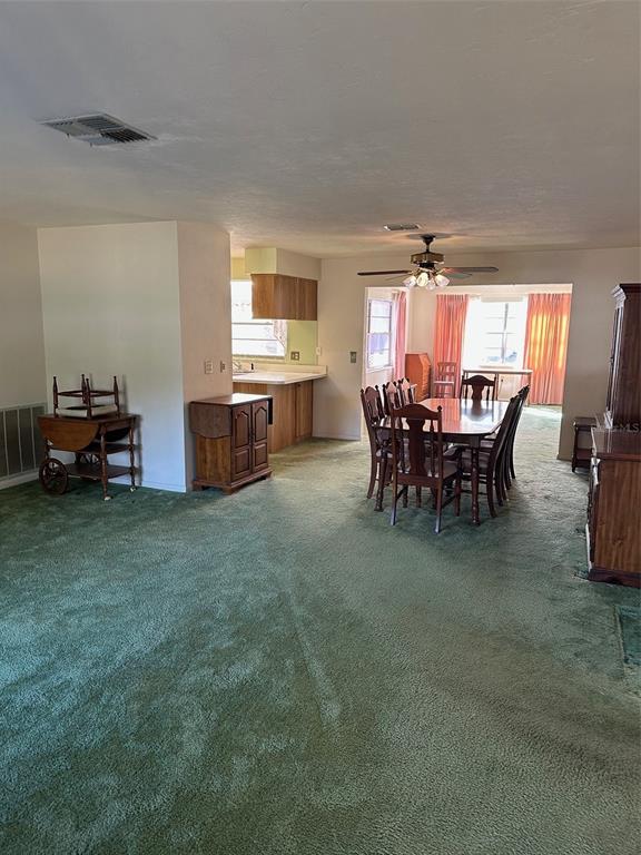 A dining room and kitchen area featuring green wall-to-wall carpeting and wood furniture — 200 S DESOTO STREET, BEVERLY HILLS, FL