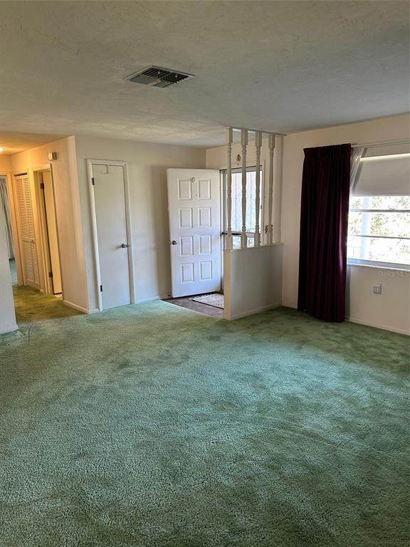 A living room features green wall-to-wall carpeting, a white room divider, and a front door — 200 S DESOTO STREET, BEVERLY HILLS, FL