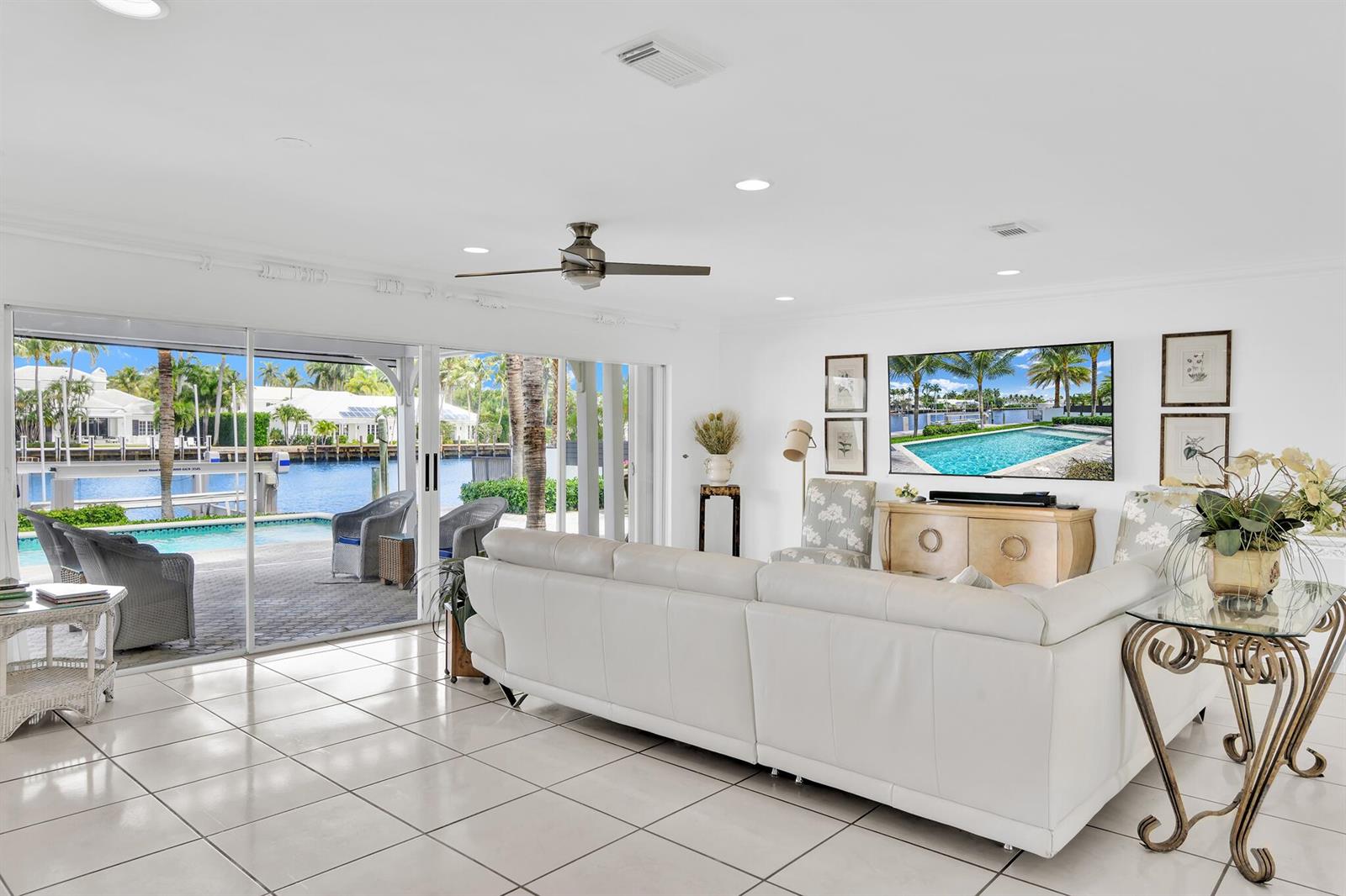 A bright living room features white tile floors, a large sectional sofa, and sliding glass doors — 3211 Karen Drive, Delray Beach FL 33483, DELRAY BEACH, FL