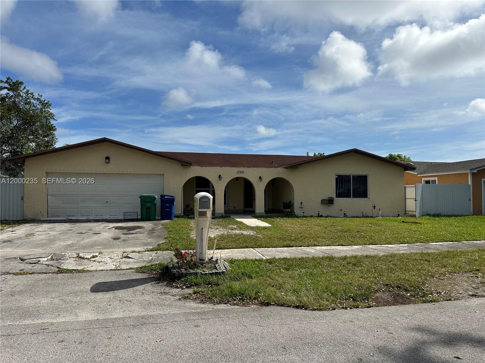 A single-story house with a beige stucco exterior, arched entryway, and an attached garage — 17335 SW 108th Ct, Miami FL 33157, MIAMI, FL