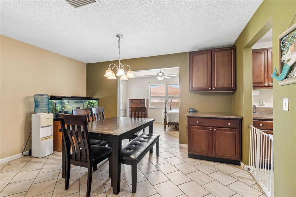 A dining room with a dark wood table, chairs, bench, and a fish tank — 9473 BAYSIDE COURT, SPRING HILL, FL