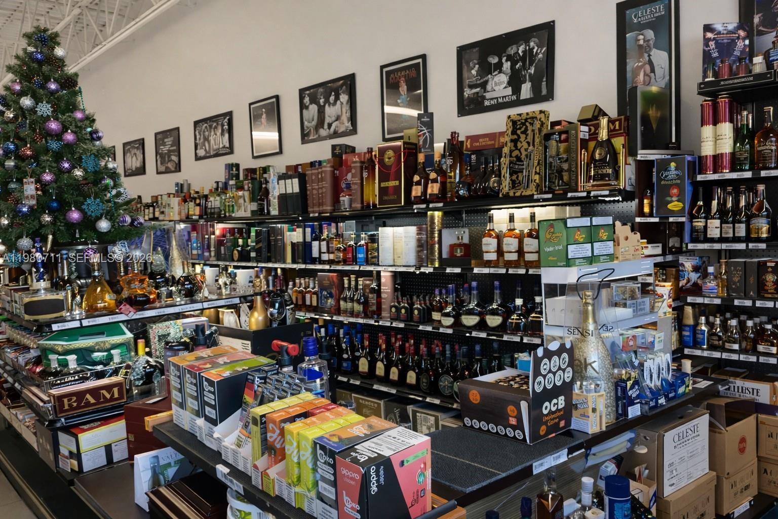 A liquor store interior features shelves stocked with various bottles and a decorated Christmas tree — 1011 Hallandale Beach Blvd, Hallandale Beach FL 33009, HALLANDALE BEACH, FL