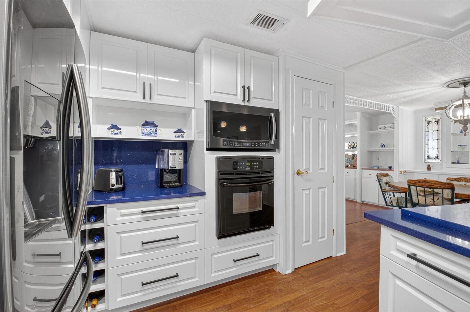 A kitchen features white cabinets, blue countertops, a built-in oven, and a microwave — 50012 Hacha, Boynton Beach FL 33436, BOYNTON BEACH, FL