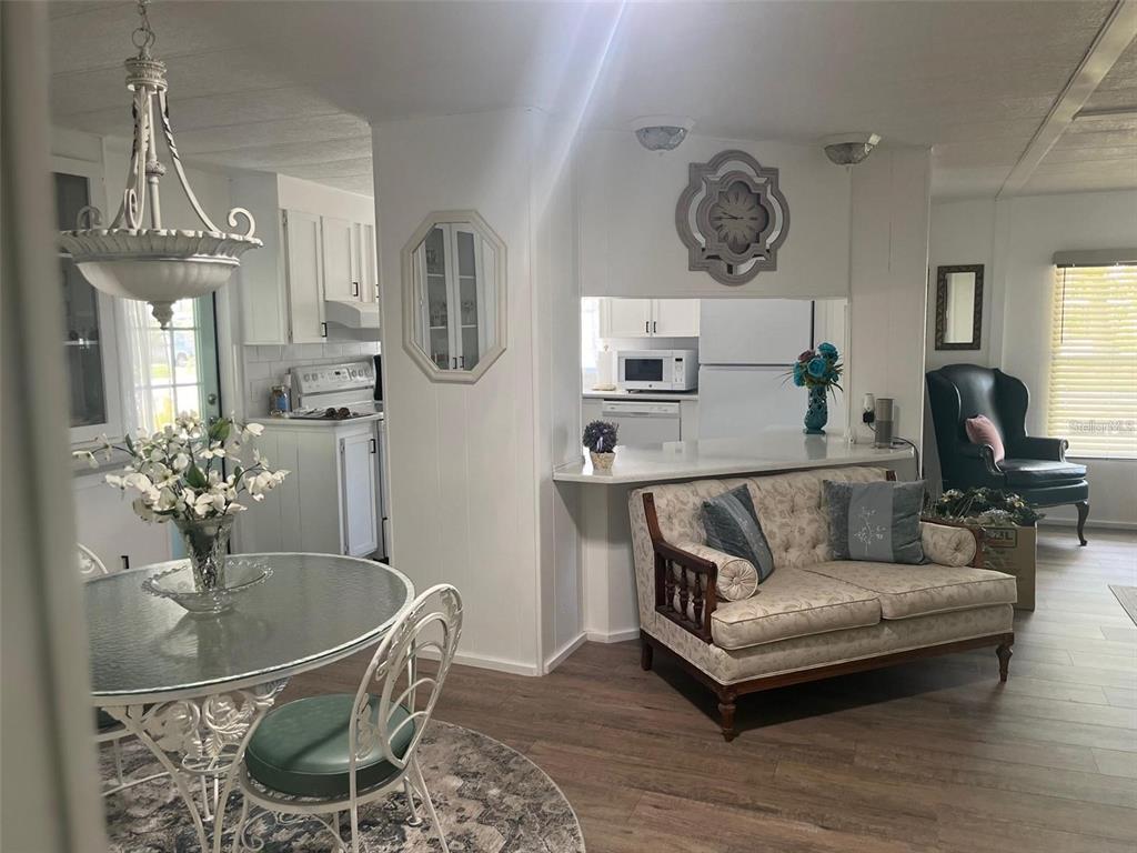 A dining area with a glass table sits beside a living room with a sofa — 33 BOBCAT TRAIL, WILDWOOD, FL