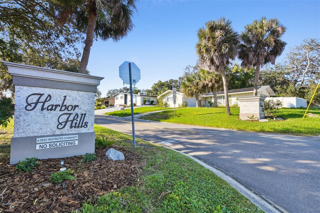 A stone monument sign for Harbor Hills stands at the entrance to a residential street — 4415 CLEARWATER HARBOR DRIVE N, LARGO, FL
