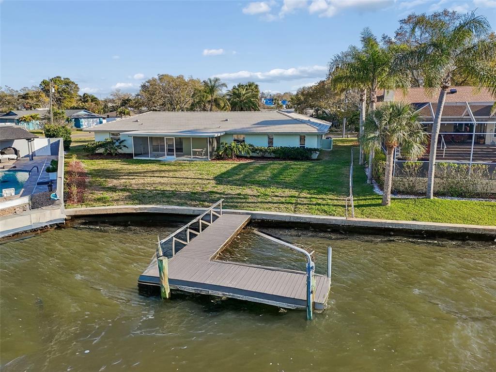 An aerial view shows a waterfront house with a screened porch and a private dock — 4415 CLEARWATER HARBOR DRIVE N, LARGO, FL