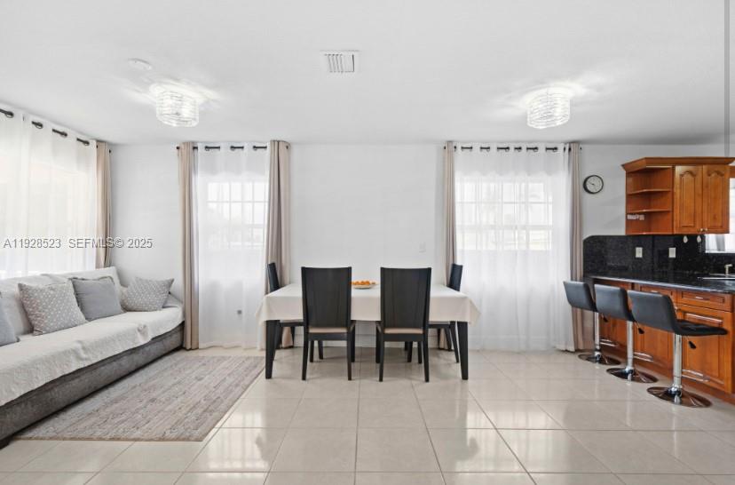 A dining area with a table and chairs sits between a living area and kitchen — 701 NE 6th St, Hallandale Beach FL 33009, HALLANDALE BEACH, FL