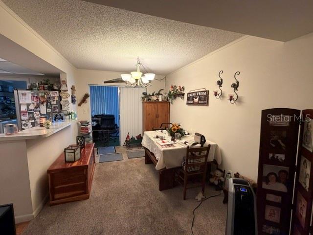 A dining area with a table, chairs, a wooden cabinet, and a kitchen counter — 1130 N LAKE PARKER AVENUE UNIT A208, LAKELAND, FL
