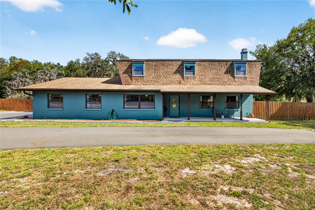 A two-story teal house with a brown shingled roof and a covered front porch — 9400 SAVOY COURT, NEW PORT RICHEY, FL