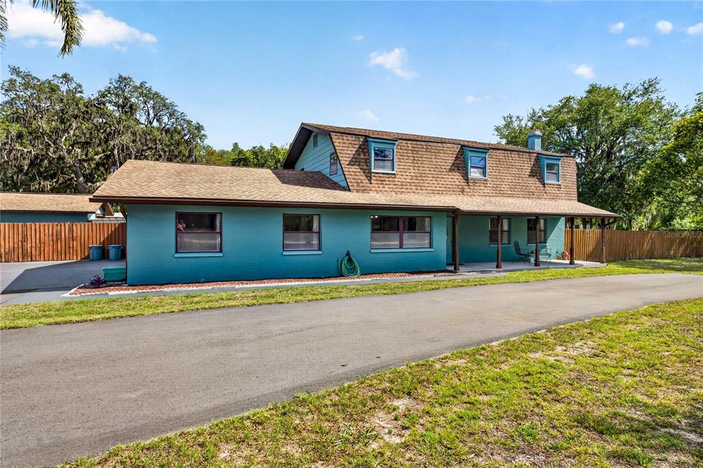 A teal two-story house with a brown shingled roof and a long paved driveway — 9400 SAVOY COURT, NEW PORT RICHEY, FL