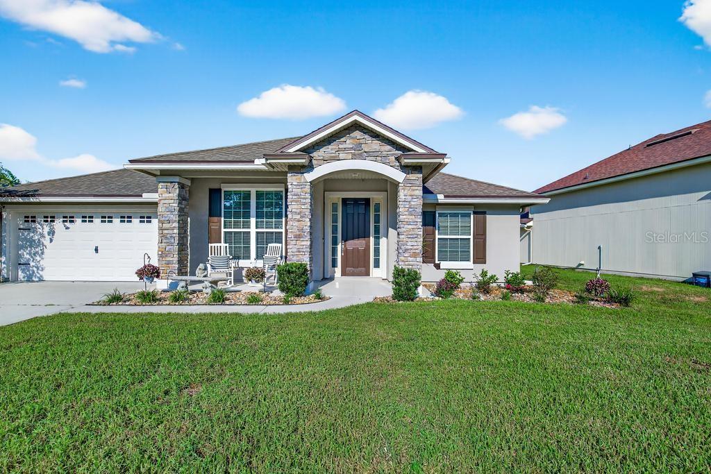 A single-story house with a stone-accented entryway, a two-car garage, and a front lawn — 86434 MOONLIT WALK CIRCLE, YULEE, FL