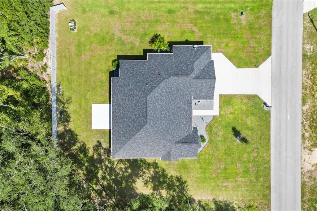 An aerial view shows a house with a dark shingled roof on a grassy lot — 16394 SE 89TH TERRACE, SUMMERFIELD, FL