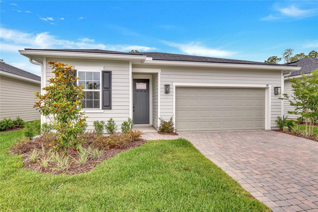 A single-story house with light gray siding, a dark front door, and a paved driveway — 198 ENCLAVE AVENUE, PALM COAST, FL
