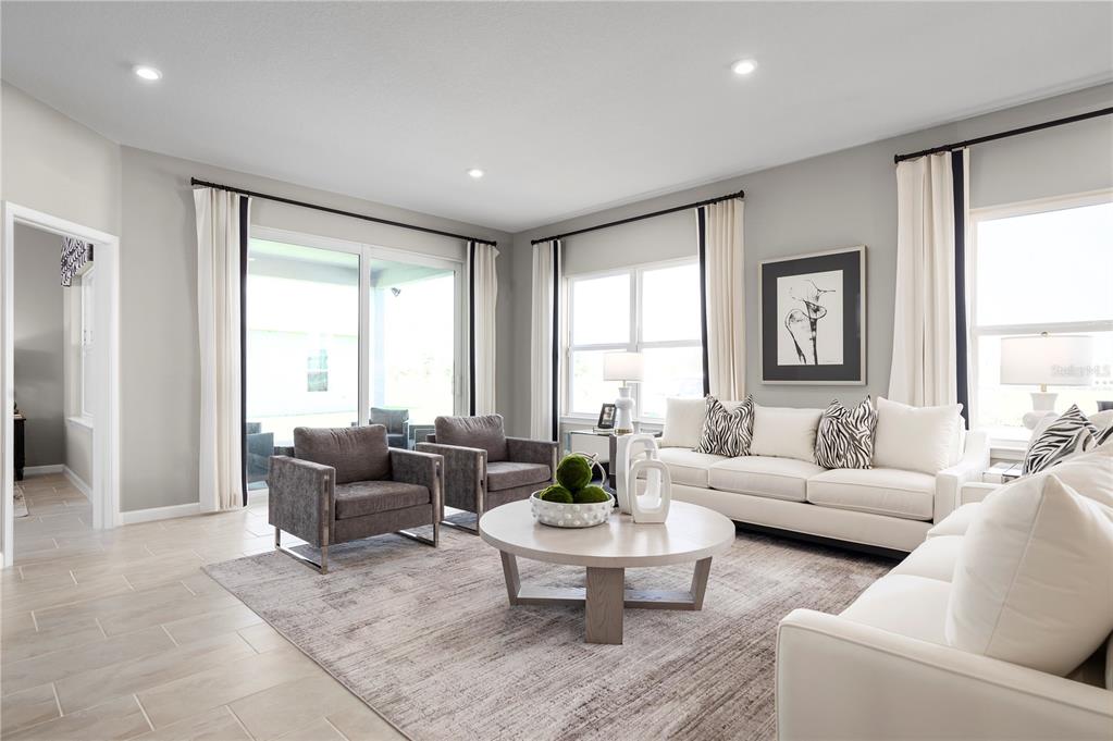 A living room features light gray walls, tile flooring, a white sofa, and two armchairs — 7348 SW 107TH LANE, OCALA, FL