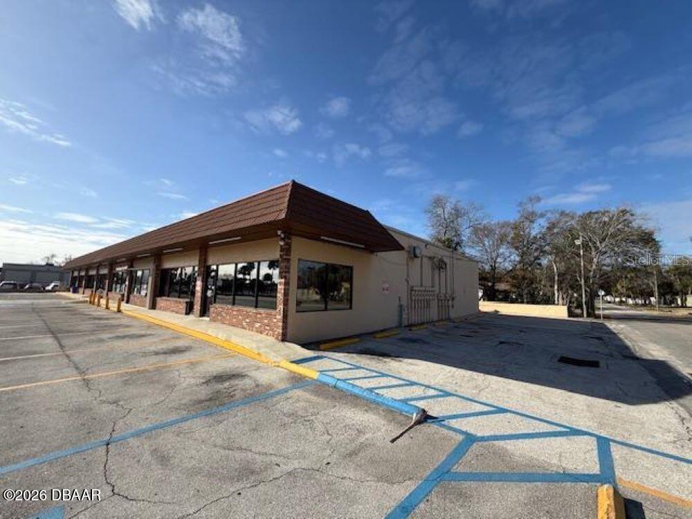 A commercial building with a brown mansard roof and a large parking lot — 1396 N NOVA ROAD, DAYTONA BEACH, FL