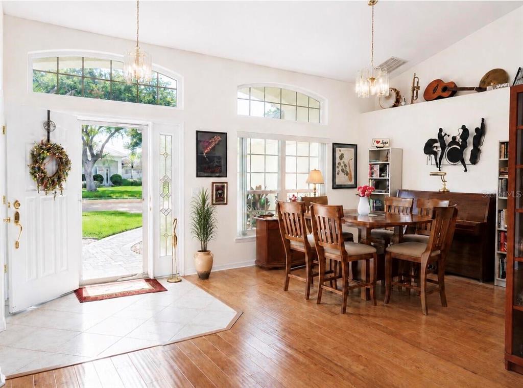A dining area with wood floors, a chandelier, and a view of the front entryway — 2713 TURNBULL ESTATES DRIVE, NEW SMYRNA BEACH, FL