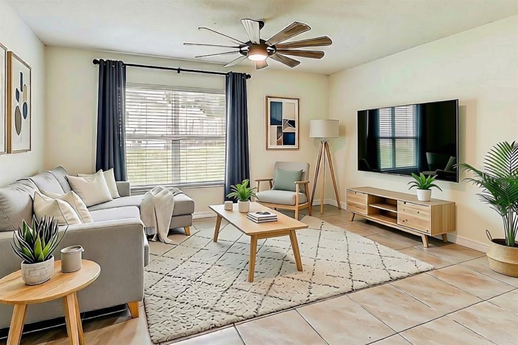 A living room features a grey sectional sofa, a wooden coffee table, and a television — 13419 CHIPPENDALE STREET, SPRING HILL, FL