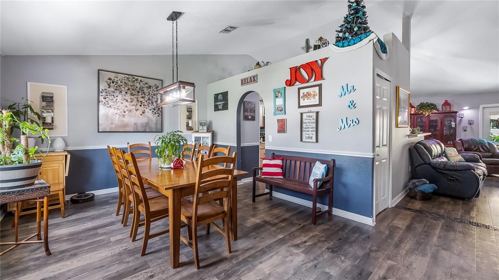 A dining room with a wooden table and chairs, a bench, and wall decor — 1101 MYRTLE LAKE VIEW DRIVE, FRUITLAND PARK, FL