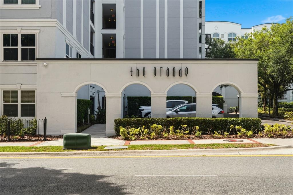 A multi-story apartment building with a gated entrance and arched architectural details — 202 E SOUTH STREET UNIT 3036, ORLANDO, FL