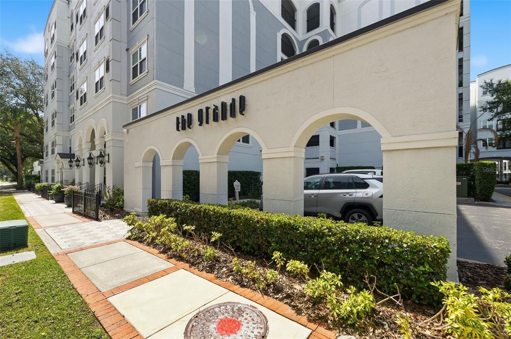A multi-story apartment building with a light gray facade and arched entryway — 202 E SOUTH STREET UNIT 3036, ORLANDO, FL