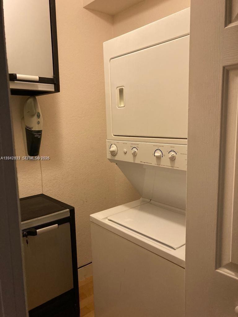 A laundry closet contains a stacked Frigidaire washer and dryer unit and a small cabinet — 7171 Bay Dr # 9, Miami Beach FL 33141, MIAMI BEACH, FL