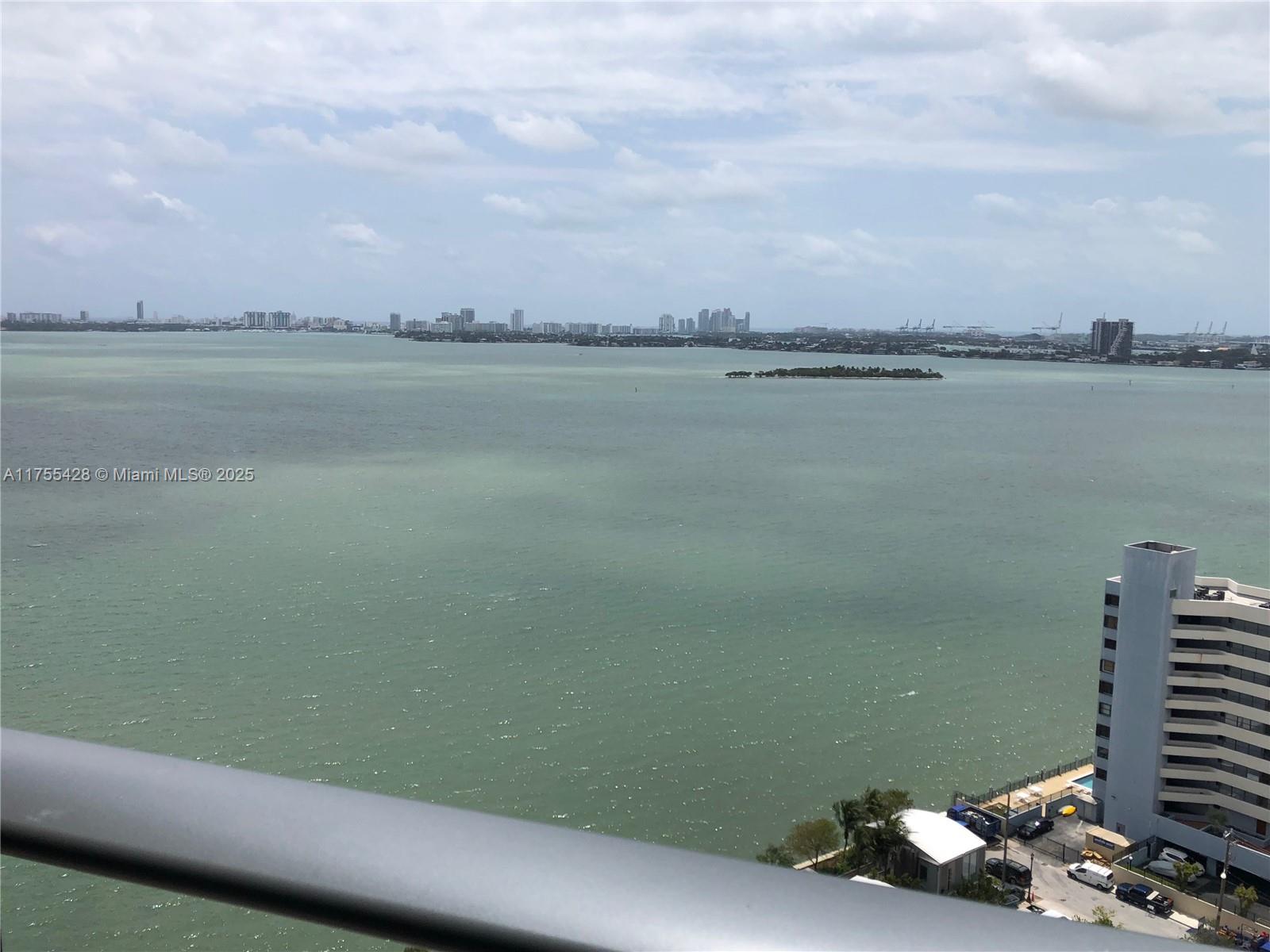 A high-angle view shows a large body of water with a distant city skyline — 650 NE 32nd St # 2006, Miami FL 33137, MIAMI, FL