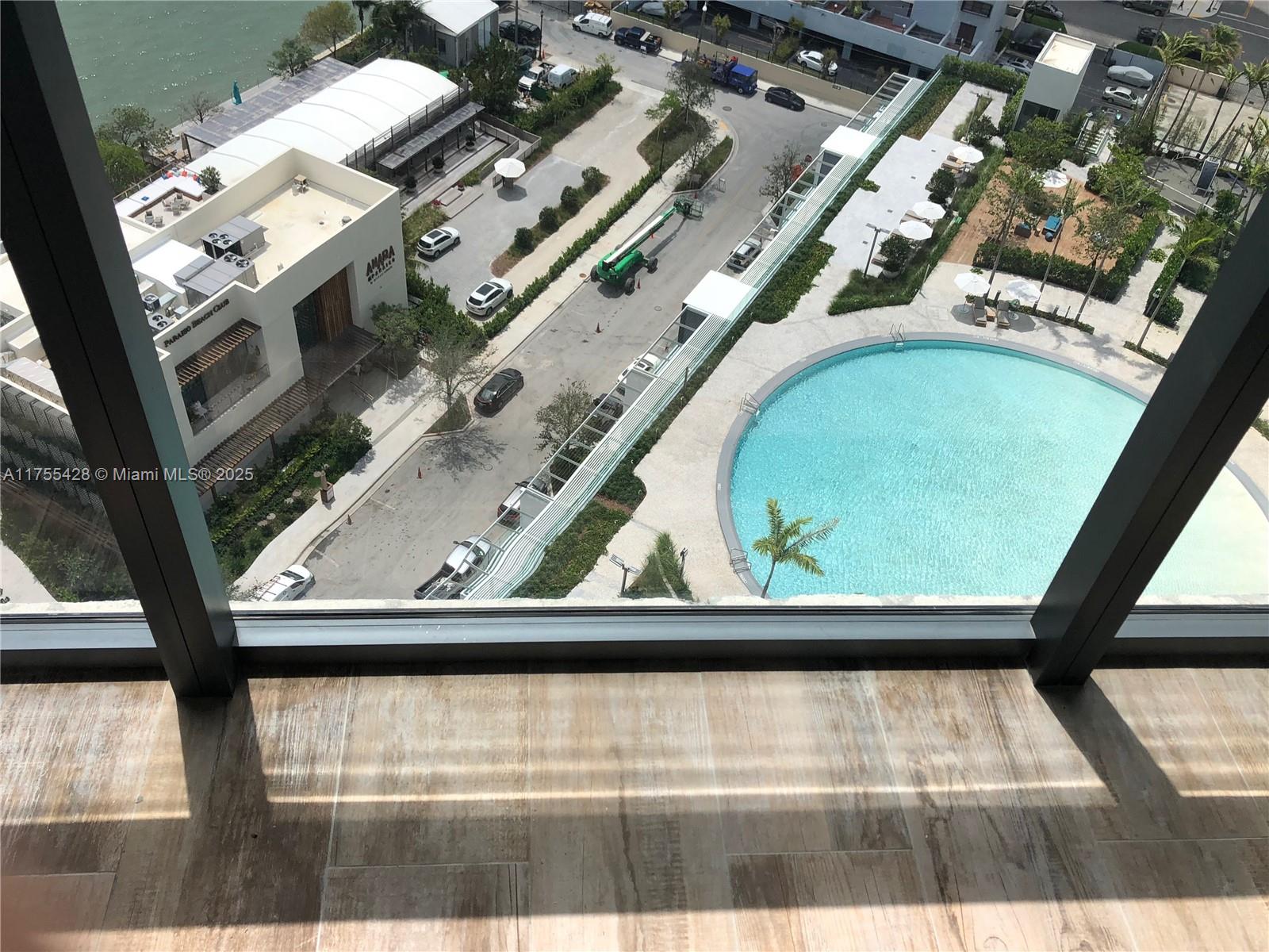 A high-angle view from a balcony shows a swimming pool, parking area, and nearby buildings — 650 NE 32nd St # 2006, Miami FL 33137, MIAMI, FL