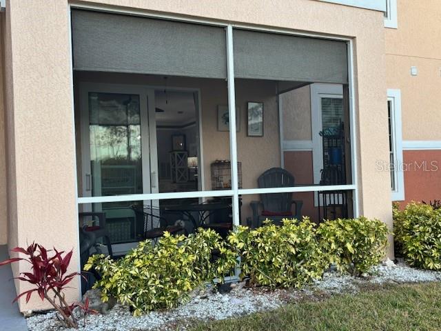 A screened-in patio features a sliding glass door, outdoor furniture, and surrounding landscaping — 4138 CENTRAL SARASOTA PARKWAY UNIT 1516, SARASOTA, FL