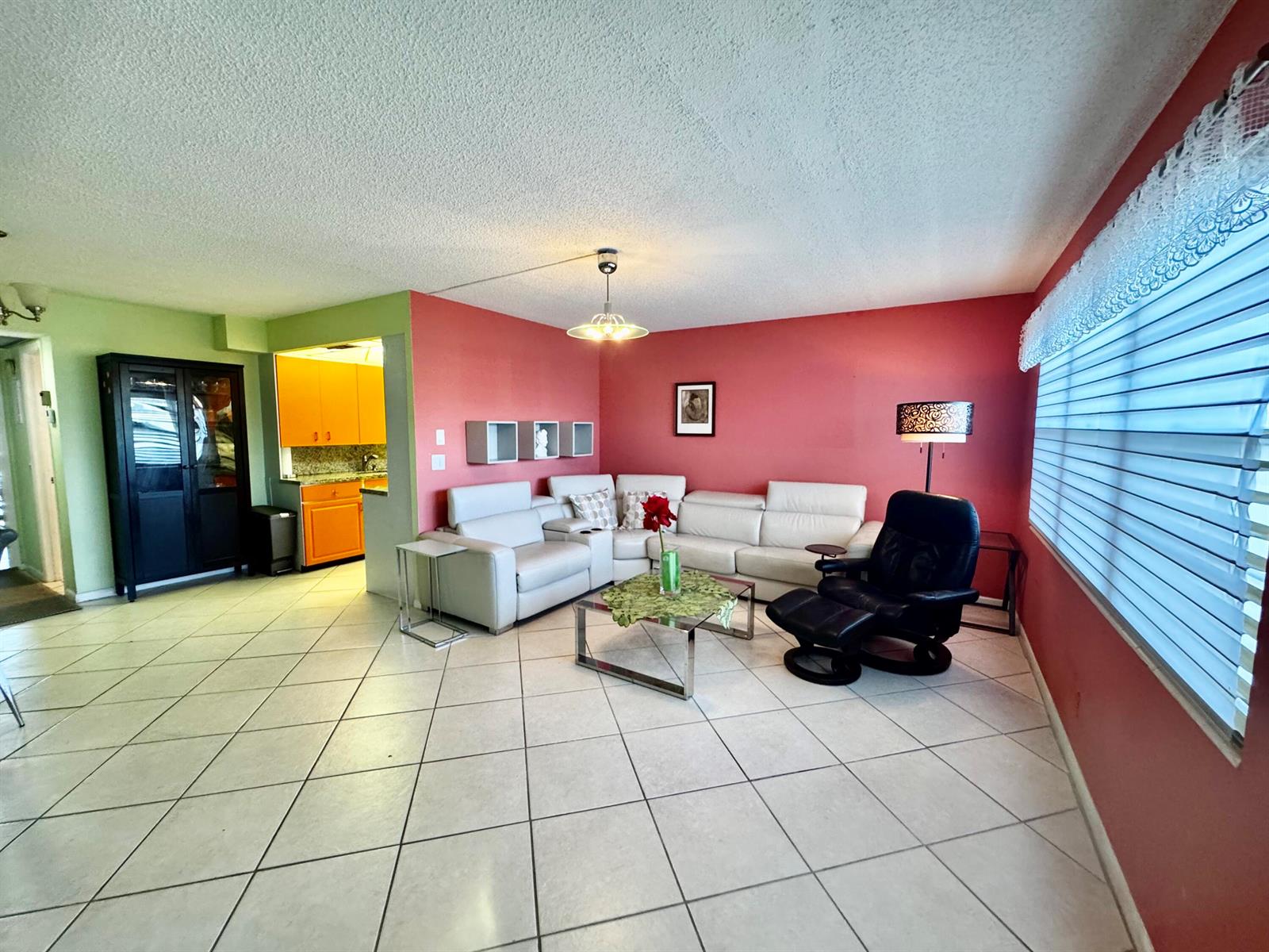 A living room with tile floors, a white sectional sofa, and red accent walls — 3058 Cambridge C # 3058, Deerfield Beach FL 33442, DEERFIELD BEACH, FL