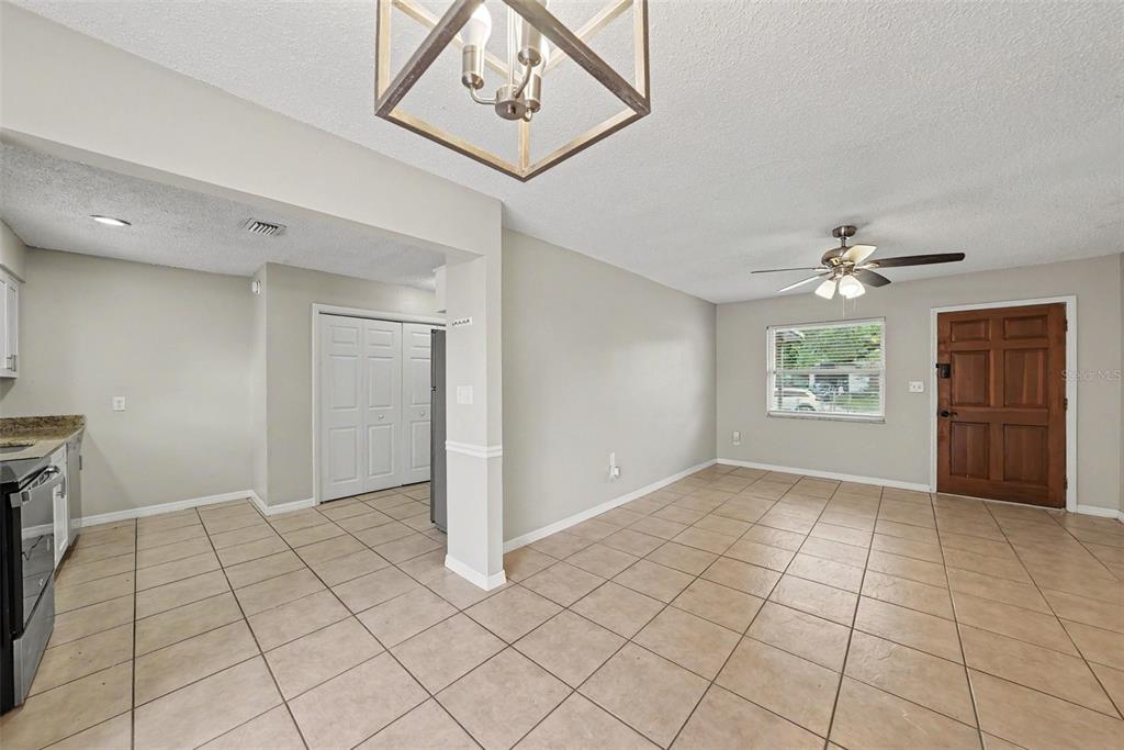 A dining area with tile flooring, a ceiling fan, and a wooden front door — 10410 N 27TH STREET, TAMPA, FL