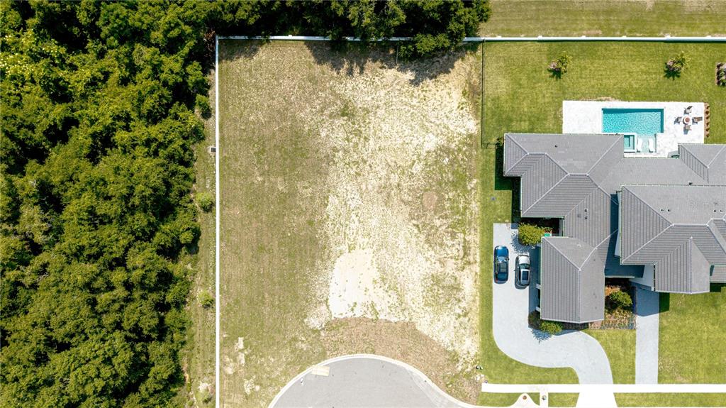 An aerial view shows a large, vacant residential lot adjacent to a house with a pool — 2504 WINDERMERE RESERVE COURT, WINDERMERE, FL