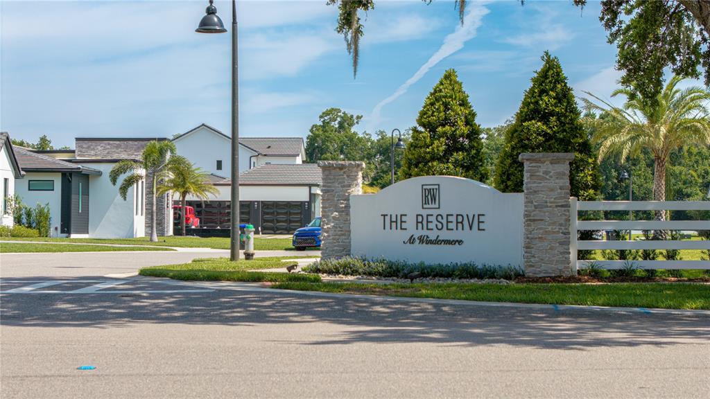 A stone monument sign for The Reserve at Windermere stands near a modern residential street — 2504 WINDERMERE RESERVE COURT, WINDERMERE, FL